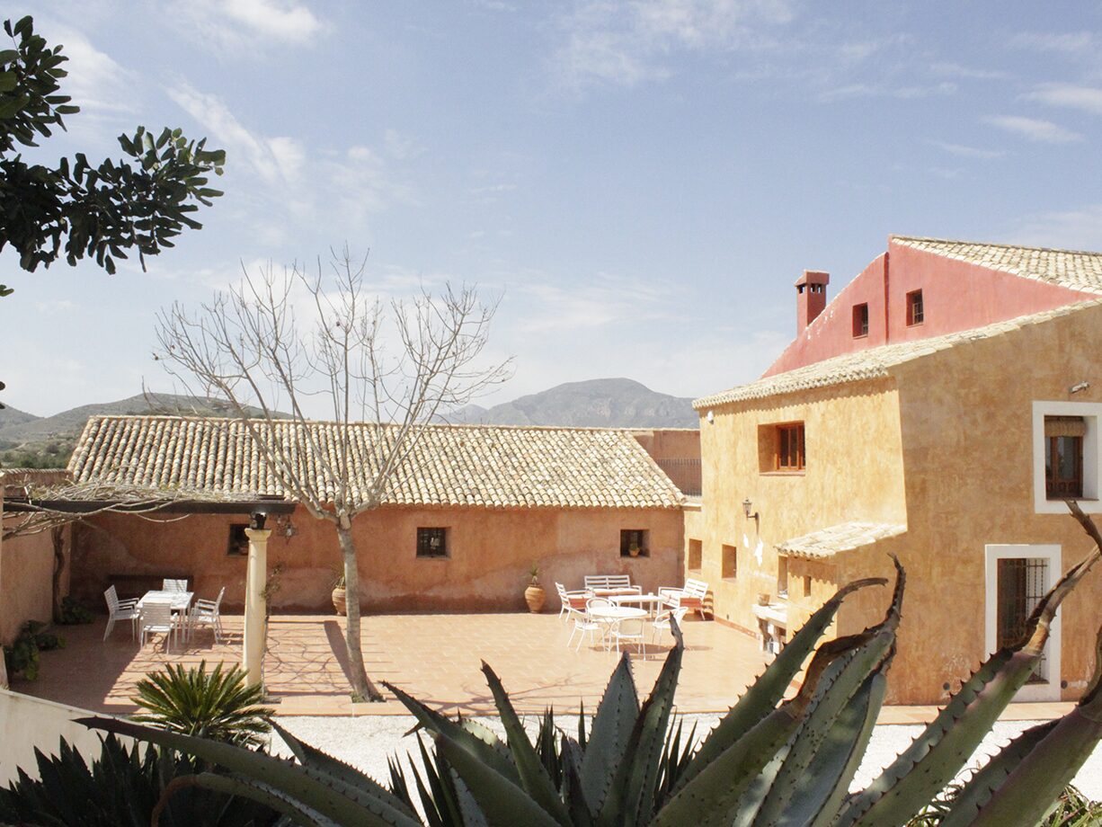 el patio de la casa del pino con la sierra al fondo