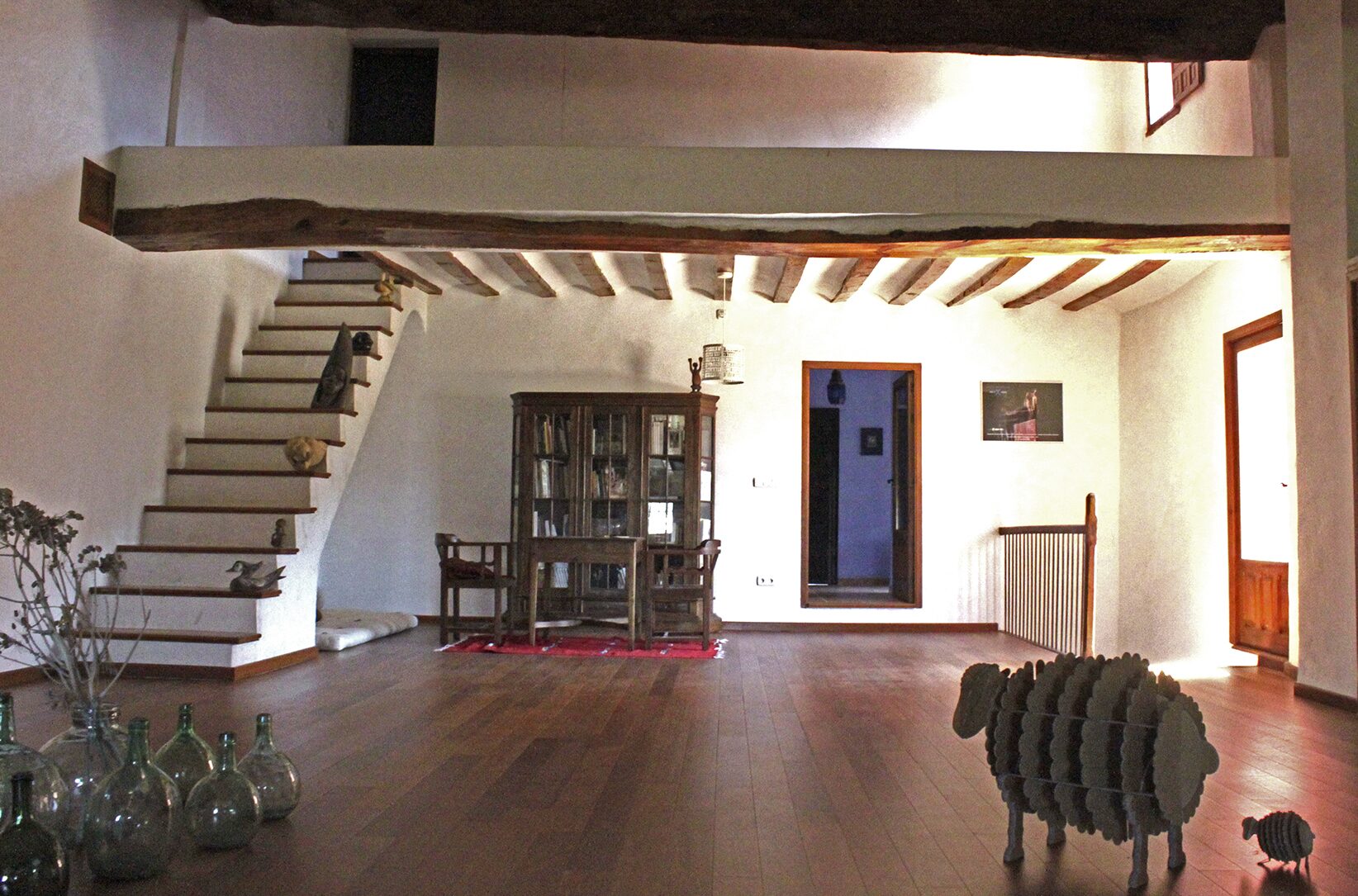 el salón a doble altura de la casa del pino, con la escalera al altillo
