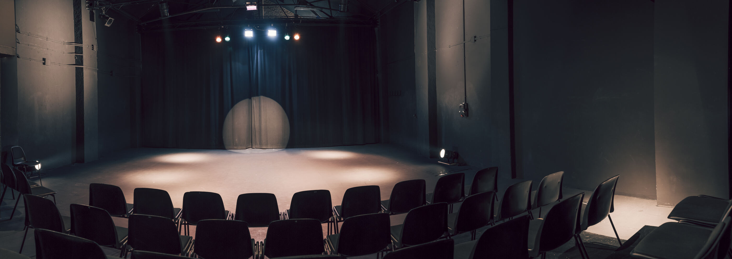 la sala: el escenario iluminado y las butacas en círculo